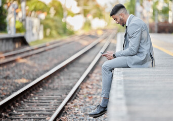Fototapeta premium Business man, phone and railway track for travel, check train schedule and browse on app in outdoors. Male person, side view and employee for commute to work, typing and internet for ticket website