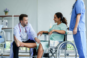 Male orthopedic doctor injury test Lifting the legs of  Hispanic female patient with a wheelchair Lift your leg up and down to check for injuries. prepare for physical therapy with physical therapist. - Powered by Adobe