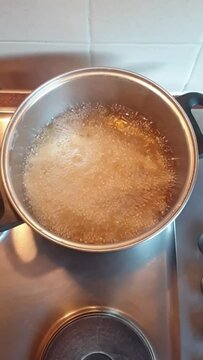 deep frying French fries in large pot full with oil on stove top