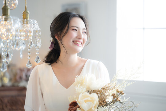メインビジュアルにも！ウェディングドレスを着た若い日本人(アジア人）女性　前撮りやブライダルなど花嫁の結婚式のイメージ　振り返る美しい表情
