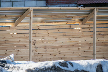 Wooden fence of the construction site on a winter day