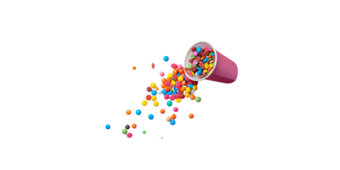 flat lay of colorful candy spilling out from paper cup on pink background