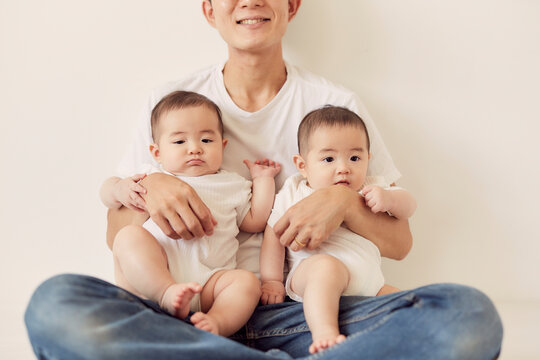 双子の赤ちゃんを抱く父親