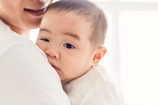 父親に抱かれて眠たそうな赤ちゃん