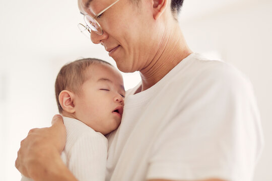 父親に抱かれて眠る赤ちゃん