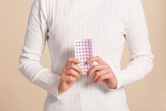 両手でピンク色の薬を持った女性