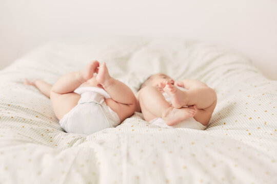 布団の上に寝転ぶ双子の赤ちゃんのお尻