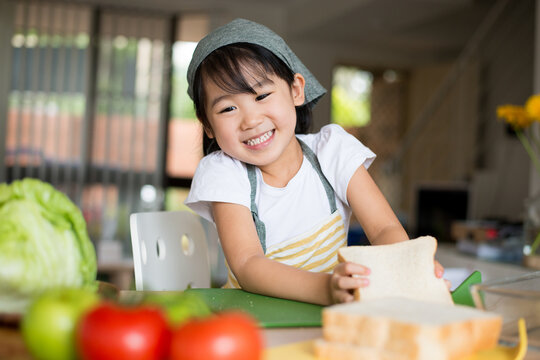 笑顔でサンドイッチを作っている女の子