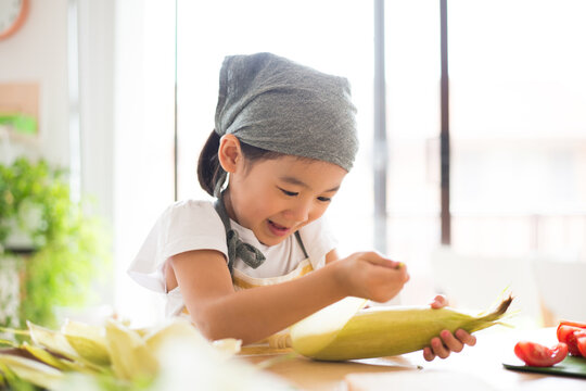 とうもろこしの皮を剥いている女の子