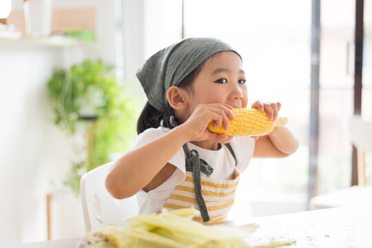 とうもろこしを食べている女の子