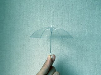 小さなビニール傘を持っている梅雨の雨の日のイメージ