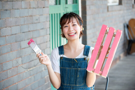刷毛と手作りの箱を持って笑っている女性