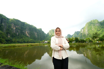 Fototapeta premium Portrait of an Asian female model wearing a hijab at a tourist attraction posing