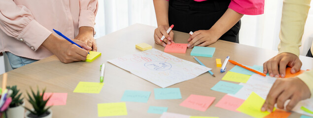 Group of young business group brainstorms ideas on colorful sticky notes. A portrait of startup...