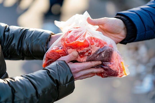 Close up view of giving of sacrificial meat on Eid al-Adha on the street