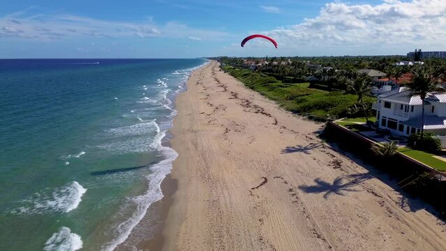 An amazing drone video following a paraglider along the beach.