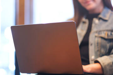 Closeup image of a young woman using and working on laptop computer in cafe - 791325414