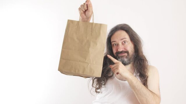 The poor man points contentedly at the paper bag and shakes his head. A man in a cheap, white, wrinkled undershirt. Bankrupt man without a job. 
