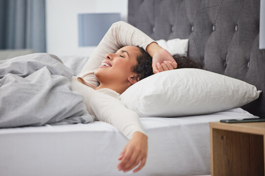 Weekend, wake up and happy woman in bed with wellness, relax and morning dream in apartment. Face, smile and girl in bedroom with peace, calm and sleep for health, comfort and natural rest in home.