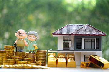 Mutual fund,Love couple senior on gold coin money and gold bar with model house on natural green...