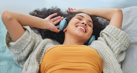 Happy, music and woman with headphones on sofa for streaming subscription, playlist and radio....