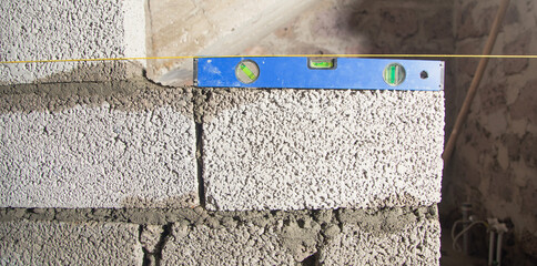 Measure level on brick wall in construction site.