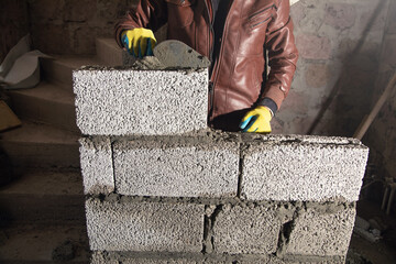 Worker builds a wall in the building site. - 791336434