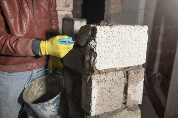 Worker builds a wall in the building site. - 791336447