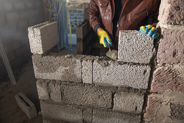 Worker builds a wall in the building site. - 791336491