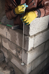 Worker builds a wall in the building site. - 791336623