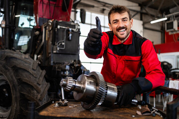 Expert mechanic repairing and servicing transmission gears for tractor agricultural machine.