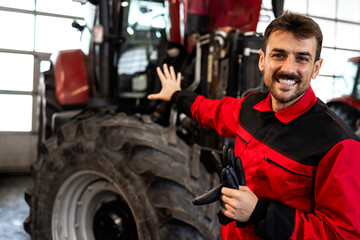 Service and maintenance of agricultural machinery. Serviceman standing by tractor.