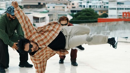 Professional hispanic break dancer practice B boy dance while multicultural friends at roof top...
