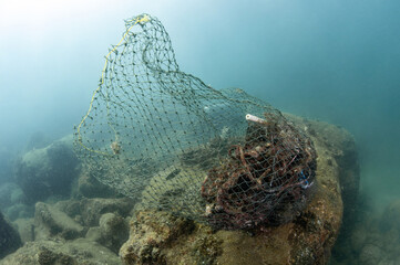 Clean up the ocean by collecting waste. Abandoned debris fishing net or ghost net and plastic garbages in the sea. Save the ocean and underwater world from trash pollution. Environmental conservation - 791348424