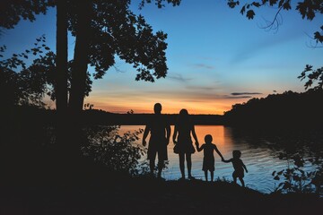 Silhouettes of a family on a trip, bonding under sunset