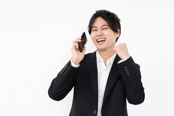 スマホで話すしガッツポーズをする男性