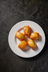 asian deep fried crispy fresh mini lava cheese salted egg yolk custard man tou bun bread vegan bao zi in plate on dark grey table chinese dim sum halal food restaurant cuisine banquet menu for cafe