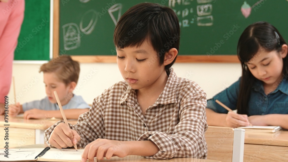 Aufkleber asian attractive boy taking a note while student writing answer in answer sheet. multicultural stude