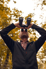 Man using binoculars for birdwatching and other observing animals in nature.