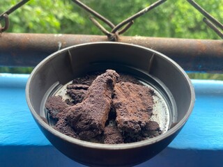 black hard coffee in the bowl which uncover for sometime and make it become harder