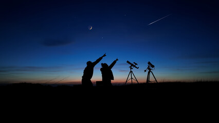 Amateur astronomers looking at the evening skies, observing planets, stars, Moon and other...