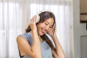 Portrait of smiling beauty asian woman happy and relax listening to music with headphones and singing, happy calm, resting ,good healthy, podcast, sound audio, listen online song at home