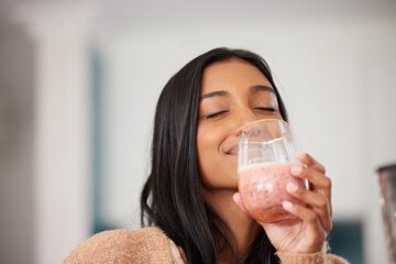 Indian woman, happy and drinking smoothie for health, nutrition and juice for detox in home. Female...