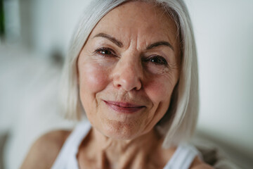 Portrait of beautiful mature woman with gray hair and soft smile.