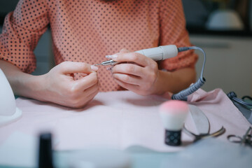 Fototapeta premium Home Manicure Process Woman Manicurist Enhancing Nail Health with Precision Tools