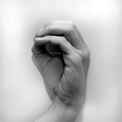 Letter O in American Sign Language (ASL) for deaf people, black and white photo of a hand