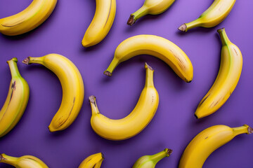 Bunches of fresh ripe bananas on a vibrant purple background, top view flat lay arrangement