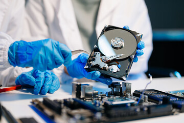 Naklejka premium Hard disk drive on the technician's desk and a computer motherboard as a component. the concept of data, hardware