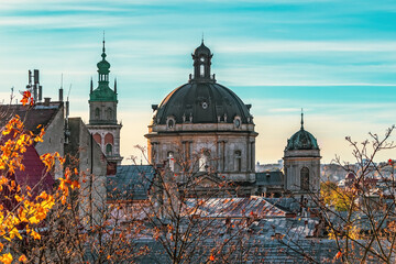 Dormition Church tower and Dominican Church dome in Lviv, Ukraine. Close-up of city roofs against...