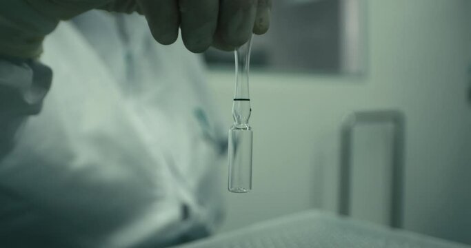 Closeup view of half filled ampule in a laboratory. Blurred background.